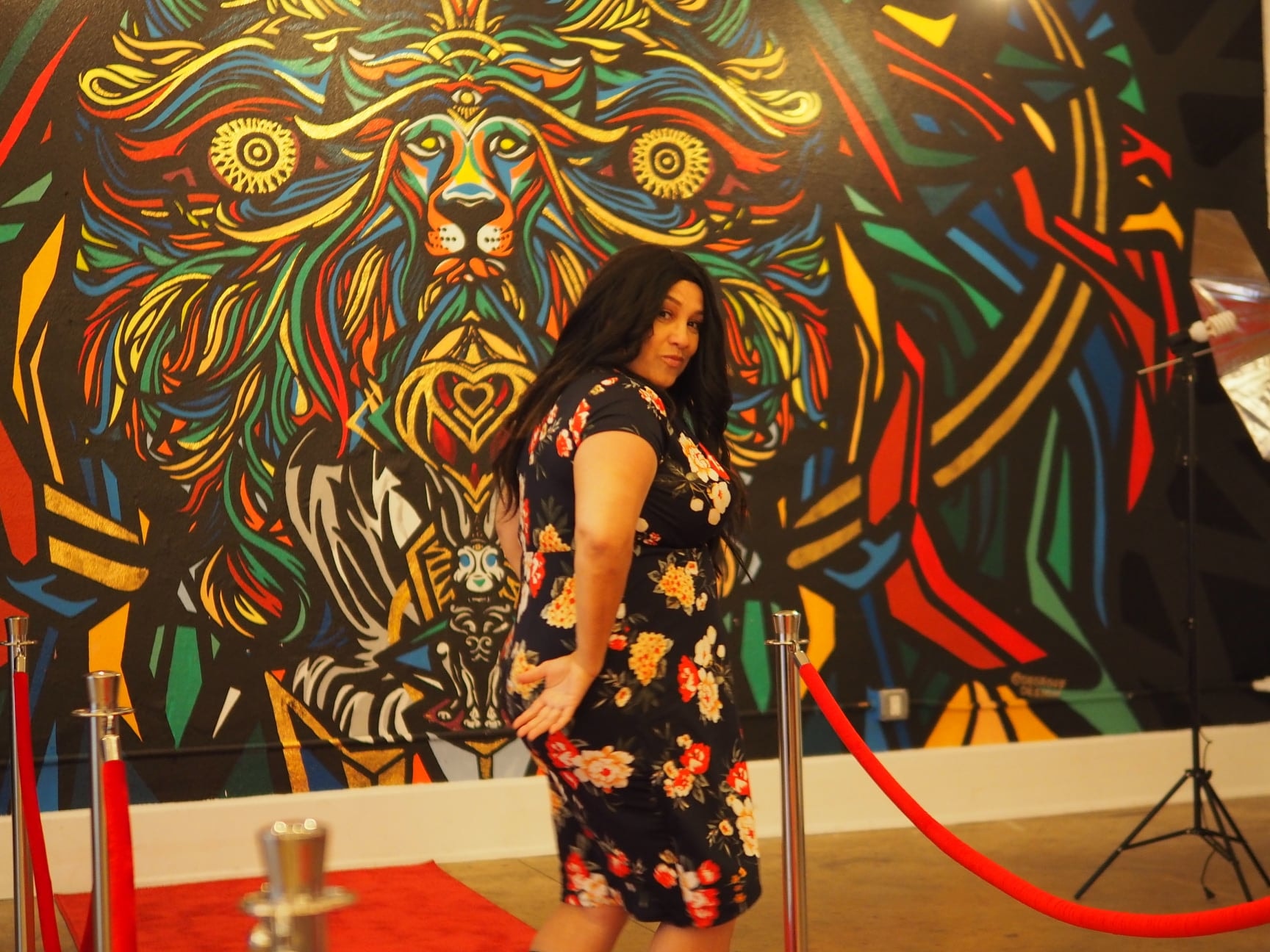 Iris posing in front of colorful lion mural