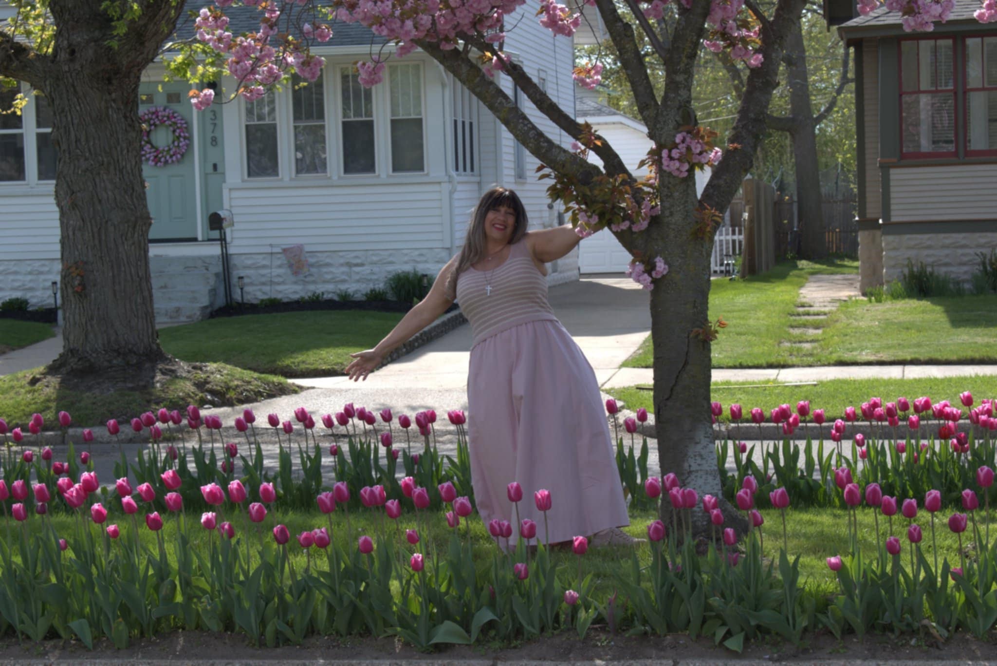 Iris in pink dress among tulips and cherry blossoms